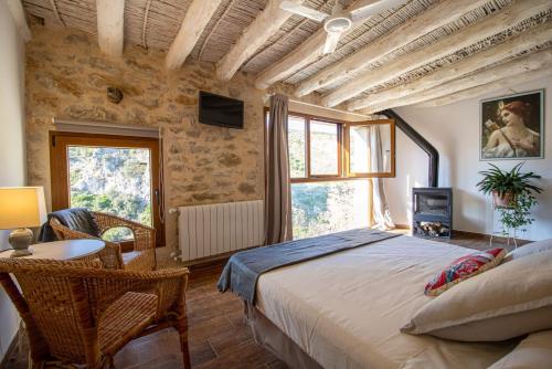 PatróにあるCasa rural Vall de Gallinera con Chimenea, piscina y jacuzzi DIANIAのベッドルーム1室(大型ベッド1台、テーブル、椅子付)