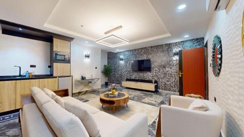 a living room with white couches and a tv at YANNA APARTMENT BY KHALIQUES in Abuja