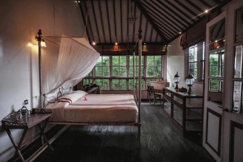 a bedroom with a canopy bed and a desk at Villa Artis in Canggu