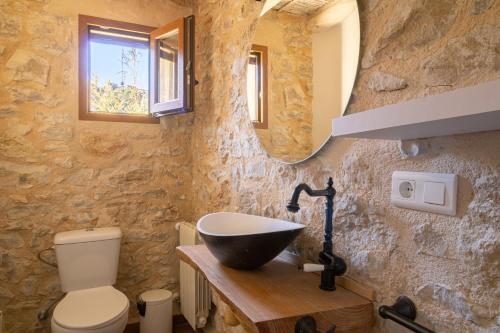 y baño con lavabo y aseo. en Casa rural Vall de Gallinera con Chimenea, piscina y jacuzzi DIANIA, en Patró