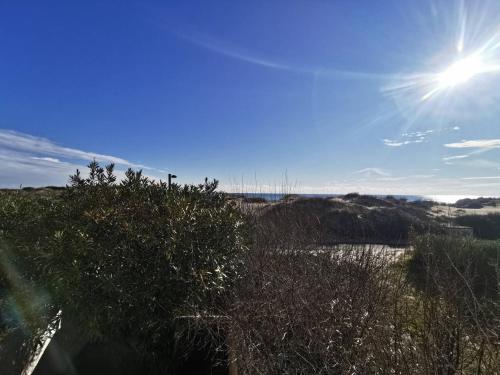 - une vue sur une colline avec le soleil dans le ciel dans l'établissement 003 Sun Village 87 Cap d'Adge, au Cap d'Agde