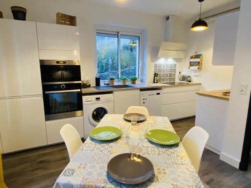 d'une cuisine avec une table et des assiettes vertes. dans l'établissement Le Fauvette, à Rodez