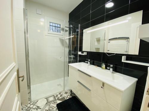 uma casa de banho com um lavatório branco e um chuveiro em Le Fauvette em Rodez