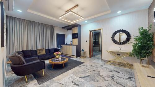 a living room with a couch and a table at YANNA APARTMENT BY KHALIQUES in Abuja