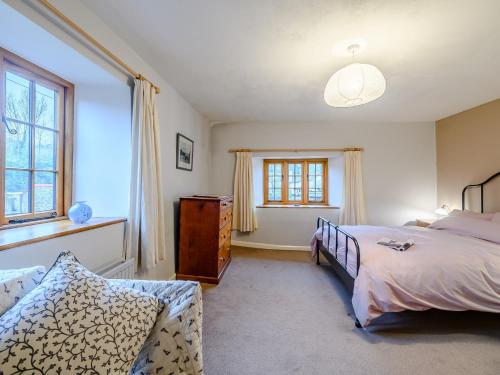 a bedroom with a bed and a couch and a window at 2 Bed in Tiverton 77884 in Bolham