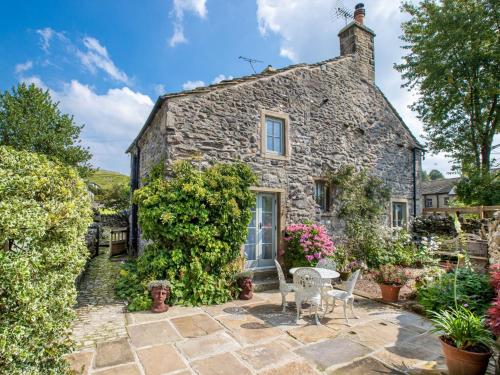 una antigua casa de piedra con mesa y sillas en 1 bed in Settle 77800, en Stainforth