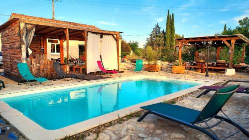 une piscine avec des chaises et une maison dans l'établissement Le P'tit Gîte Gardéchois, piscine Ardèche - 12pers, à Saint-André-de-Cruzières