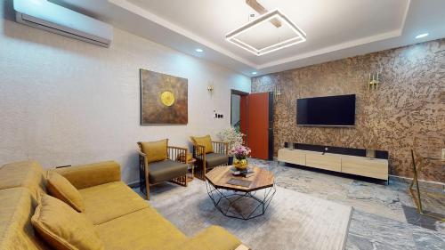 a living room with a couch and a tv at YANNA APARTMENT BY KHALIQUES in Abuja