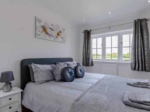 1 dormitorio blanco con 1 cama grande con almohadas azules en 3 bed in Malton 78311 en Kirby Misperton