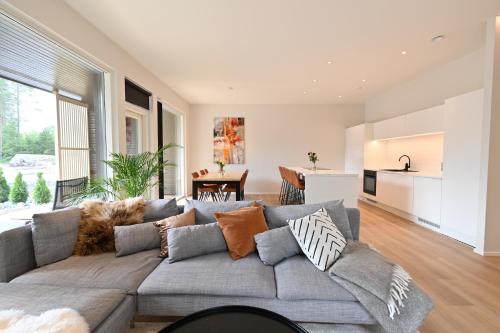 ein Wohnzimmer mit einer grauen Couch mit Kissen in der Unterkunft Apartment RIVA in Turku