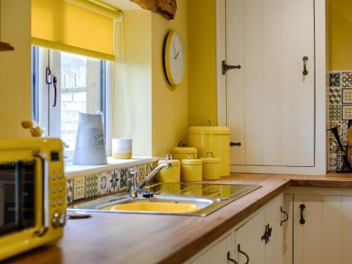 a kitchen with a sink and a clock on the wall at 1 Bed in 78487 in Hunwick