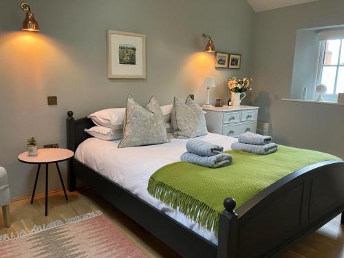 een slaapkamer met een bed met handdoeken erop bij 1 Bed in Masham G0089 in Thornton Watlass