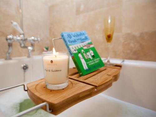 a candle and a book sitting on a bathroom sink at 1 Bed in Masham G0089 in Thornton Watlass