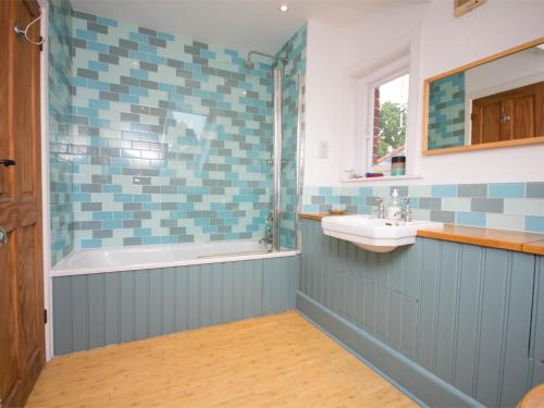 a bathroom with a tub and a sink and a shower at 3 Bed in Studland DC071 in Studland