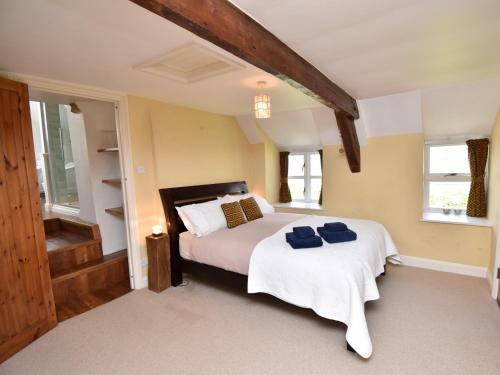 a bedroom with a bed with two blue towels on it at 3 Bed in Corfe Castle DC084 in Corfe Castle