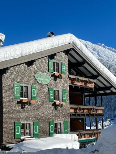 a large building with snow on the side of it at Gästehaus Fritz in Mittelberg