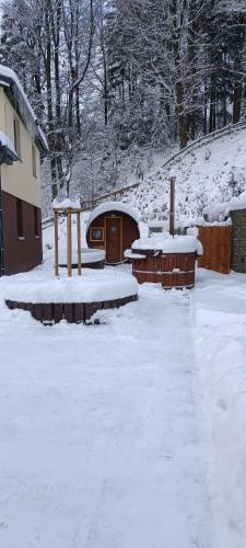 a yard covered in snow next to a building at Chata U dědka in Prostřední Bečva