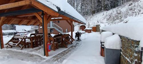 a snow covered porch of a house with snow on the ground at Chata U dědka in Prostřední Bečva