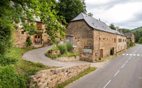 an old stone building on the side of a road at Chambre d'hôtes Le Cascadou in Banassac
