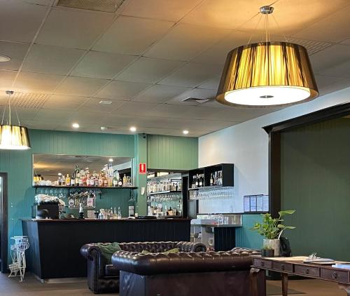 a bar with a couch and a counter with drinks at Oakview Country House Maffra in Maffra