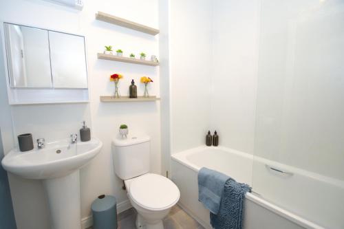 a white bathroom with a toilet and a sink at Peedie Picky Townhoose - STL OR00094F in Orkney