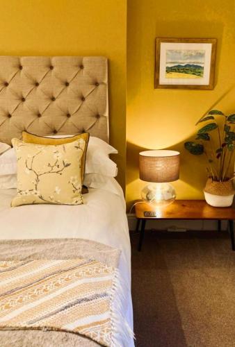 a bedroom with a bed and a table with a lamp at Wells Cottage in Malvern Wells