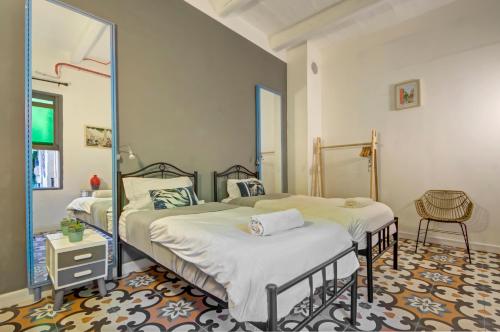 a bedroom with two beds and a mirror at Boho Rooms Sliema in Sliema