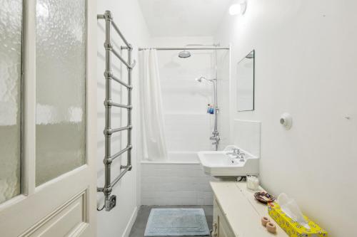 une salle de bain blanche avec un lavabo et une douche dans l'établissement Spacious apartement 'Canal Saint Martin' for 6 by Weekome, à Paris