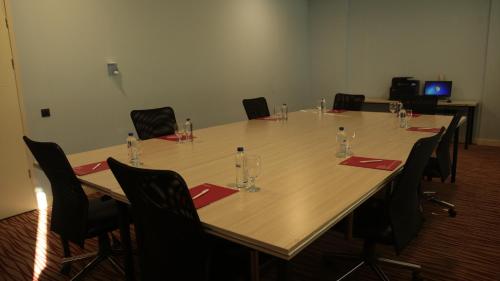 a conference room with a long wooden table with chairs at Ramada By Wyndham Soma in Soma