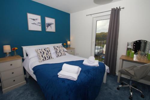 een slaapkamer met een bed met blauwe muren en een raam bij Peedie Picky Townhoose - STL OR00094F in Orkney