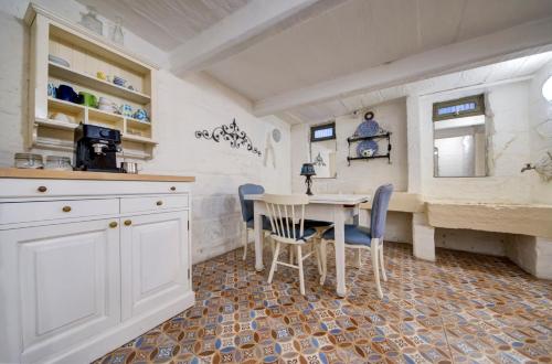 a kitchen with a table and chairs in a room at Boho Rooms Sliema in Sliema