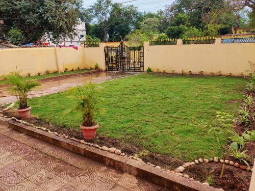 a yard with two potted plants and a fence at Sangeeta's Homestay in Jagdalpur