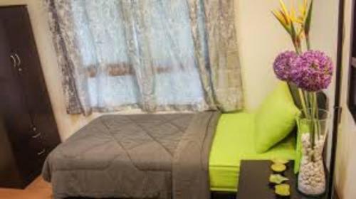 a bedroom with a bed and a window with purple flowers at Worker's Apartman-Munkásszálló in Nyíregyháza