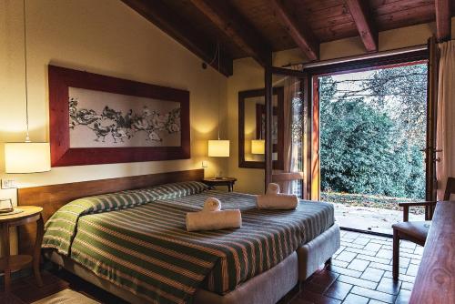 a bedroom with a bed and a large window at Corte San Mattia in Verona