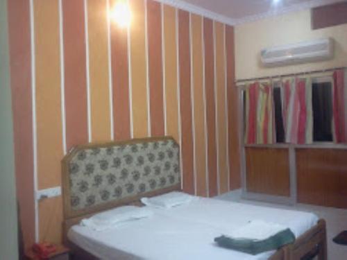 Habitación pequeña con cama y estante para libros en HOTEL SHANTIDOOT , Gadarwara en Gādarwāra