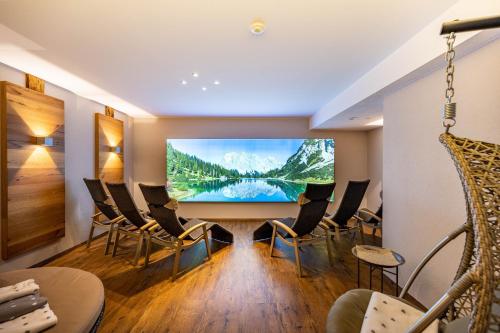 a meeting room with a large screen tv in a building at Rustika - Appartements & Spa in Ehrwald