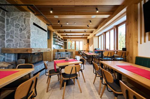 a restaurant with tables and chairs and a fireplace at Ribniška koča in Ribnica na Pohorju