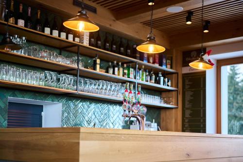 a bar with many bottles and glasses on the wall at Ribniška koča in Ribnica na Pohorju