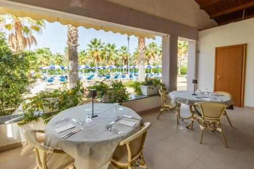 two tables in a room with a view of a pool at Prince Franklyn Hotel in Santa Maria di Castellabate