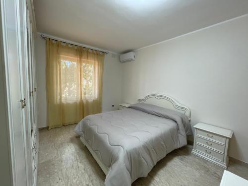 ein weißes Schlafzimmer mit einem Bett und einem Fenster in der Unterkunft Fontana Stella in Telese