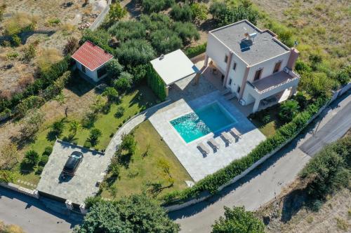 an aerial view of a house with a swimming pool at Vlasis' Eden Villa in Sálakos