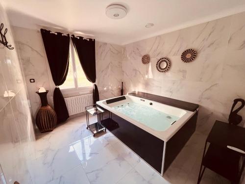 ein großes Badezimmer mit Whirlpool-Badewanne in der Unterkunft Domaine Amourella in Lambesc