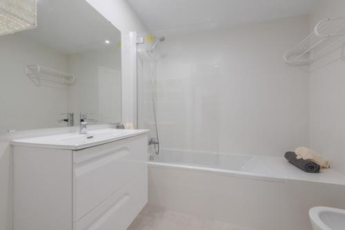 uma casa de banho branca com um lavatório e uma banheira em Apartment Blavamar em El Port