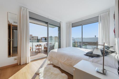1 dormitorio con cama y ventana grande en Penthouse Rosas 1C, en Puerto Pollensa