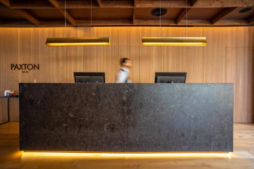 a man standing behind a black counter in a room at Hotel Paxton Barcelona in Barcelona