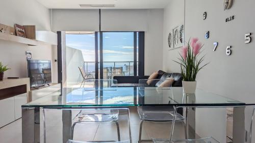 uma sala de jantar com uma mesa de vidro e cadeiras em SUNSET WAVES lovely apartment em Benidorm