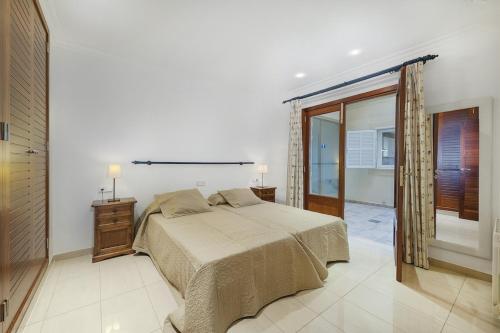 een slaapkamer met een bed en een groot raam bij Apartment VistaMar I in Port de Pollença
