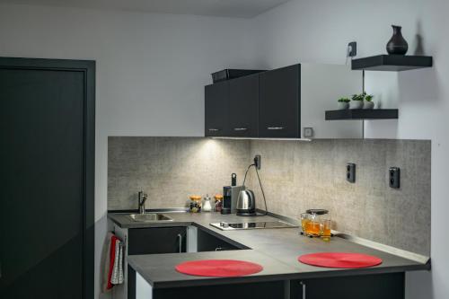 a kitchen with red circles on the counter top at black well in Jablonec nad Nisou
