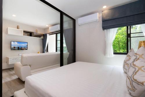 a bedroom with a large white bed and a couch at F12 Номер Люкс Бассейн Рубль ВАТСАП669З582I976 in Nai Yang Beach