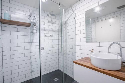 a bathroom with a sink and a glass shower at Crows Nest Gem - with parking in Sydney